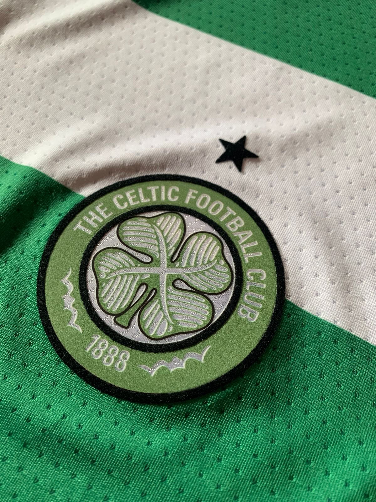 Detalle del escudo Celtic FC en camiseta verde y blanca