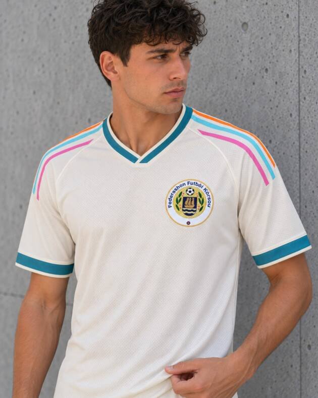 Camiseta Curazao 2026 crema con cuello y puños turquesa